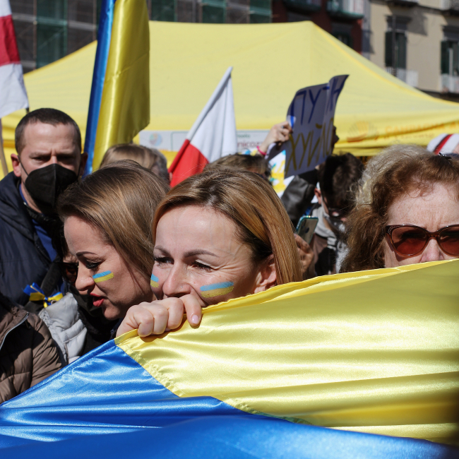 Mehrere Menschen mit einer Flagge der Ukraine.