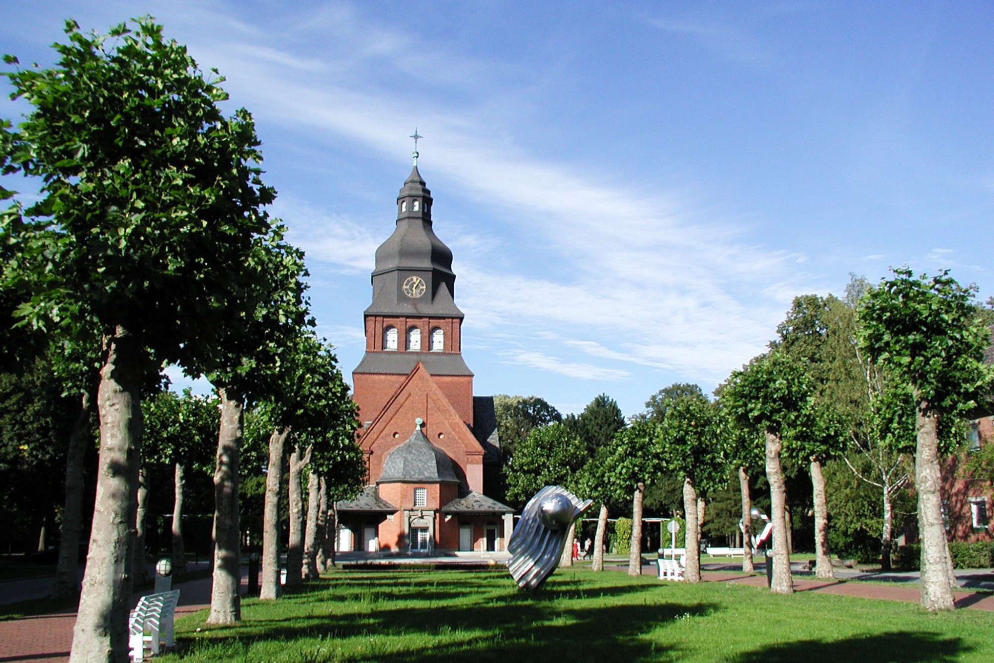Blick über eine Allee auf die Stiftskirche auf dem Gelände des Evangelischen Johannesstifts.