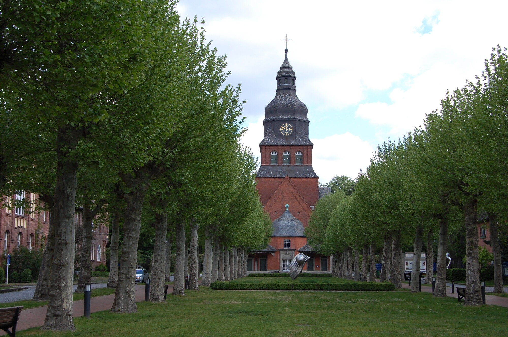 Blick über eine Allee auf die Stiftskirche auf dem Gelände des Evangelischen Johannesstifts.