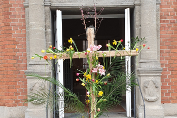 geschmücktes Kreuz vor der Kirche